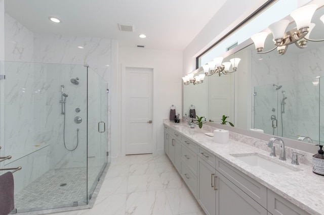 bathroom with a chandelier, vanity, and a shower with door