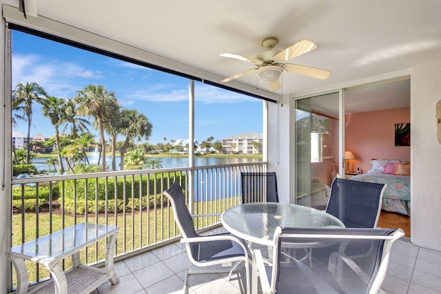 sunroom with a water view and ceiling fan