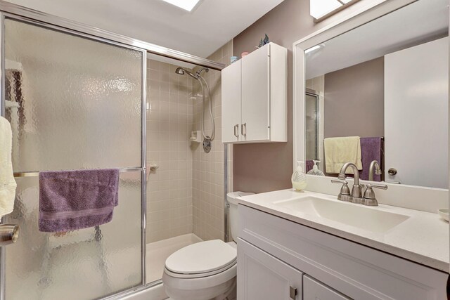 bathroom featuring vanity, toilet, and walk in shower