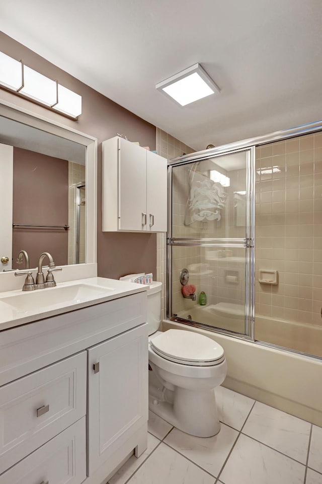 full bathroom with shower / bath combination with glass door, tile patterned flooring, vanity, and toilet