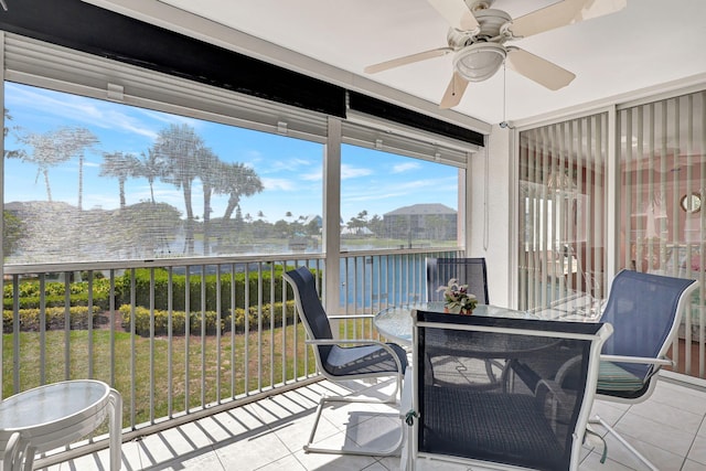 sunroom / solarium with a water view and ceiling fan