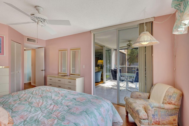 bedroom featuring floor to ceiling windows, a textured ceiling, access to outside, ceiling fan, and light hardwood / wood-style floors