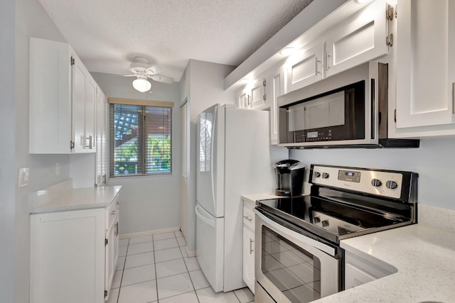 kitchen featuring white cabinetry, a textured ceiling, light tile patterned floors, stainless steel appliances, and light stone countertops