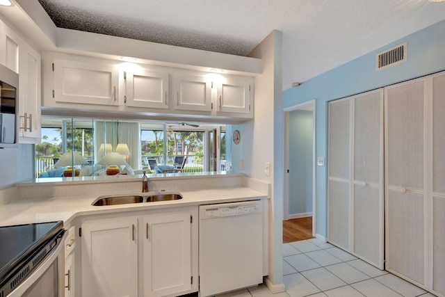 kitchen featuring white cabinetry, dishwasher, sink, and light tile patterned floors