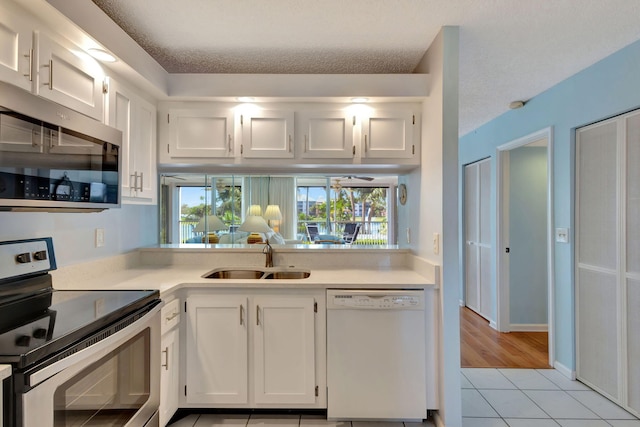 kitchen featuring white cabinetry, appliances with stainless steel finishes, sink, and light tile patterned flooring