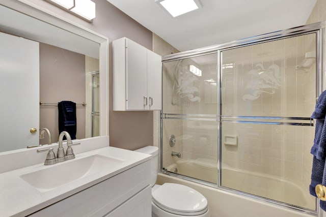 full bathroom featuring enclosed tub / shower combo, vanity, and toilet