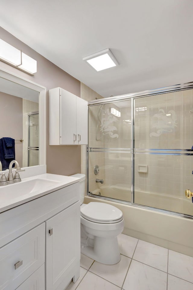 full bathroom with enclosed tub / shower combo, vanity, and toilet