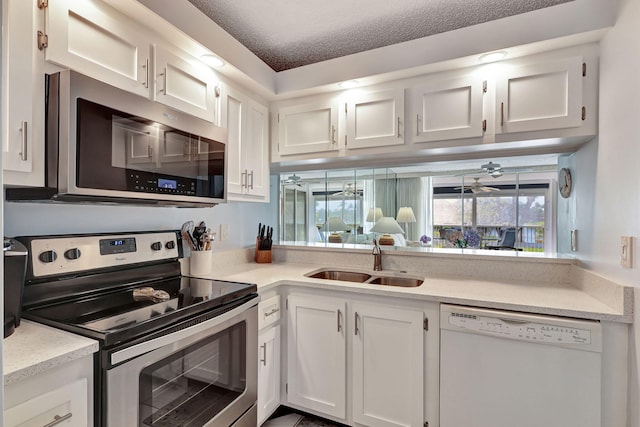 kitchen featuring white cabinets, sink, ceiling fan, a textured ceiling, and appliances with stainless steel finishes