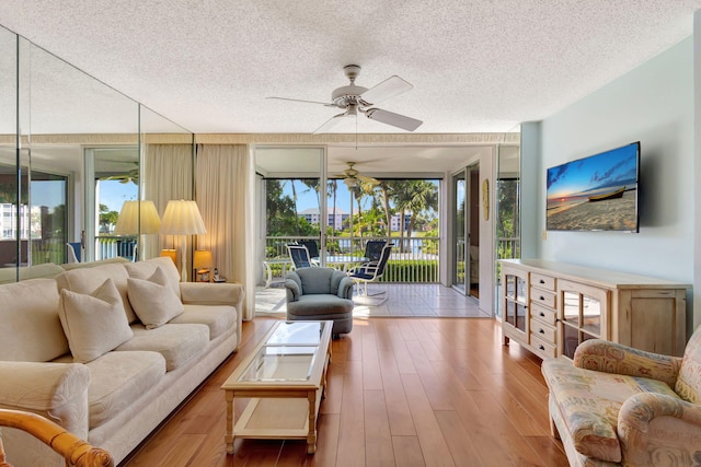 living room featuring floor to ceiling windows, a textured ceiling, ceiling fan, and light hardwood / wood-style floors