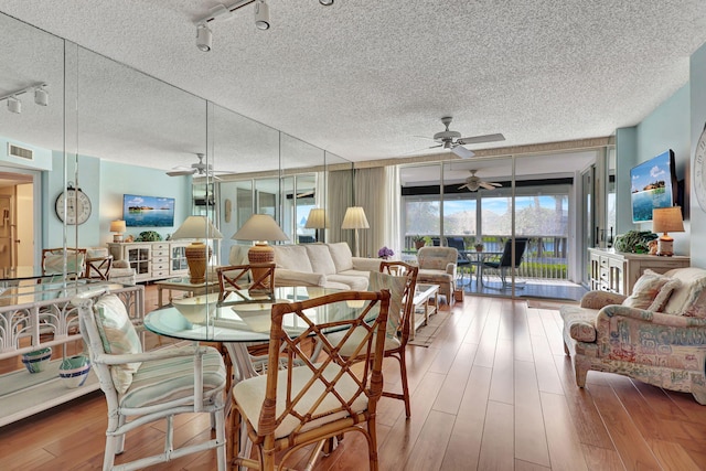 dining area featuring a textured ceiling, ceiling fan, hardwood / wood-style floors, and track lighting