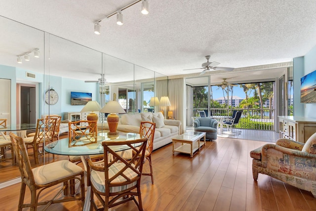 dining room featuring hardwood / wood-style floors, a textured ceiling, and ceiling fan