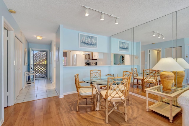 dining area featuring light hardwood / wood-style floors and a textured ceiling