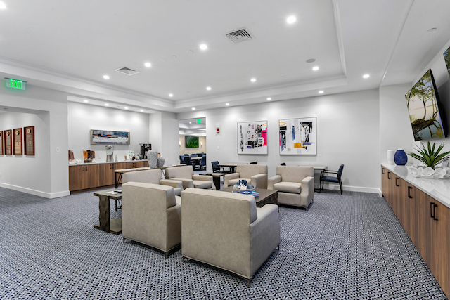 carpeted living room featuring a raised ceiling and crown molding