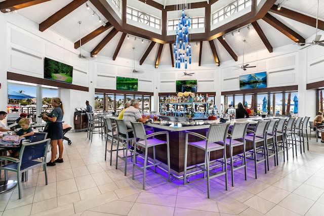 tiled dining space featuring beamed ceiling, ceiling fan, and high vaulted ceiling