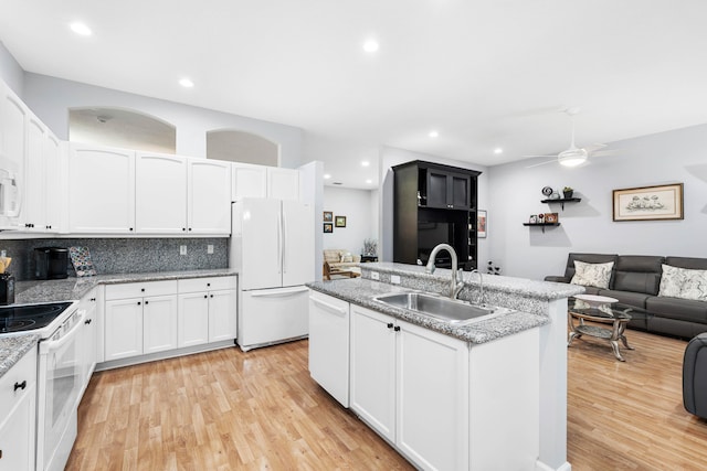 kitchen featuring sink, white cabinets, light hardwood / wood-style floors, and white appliances