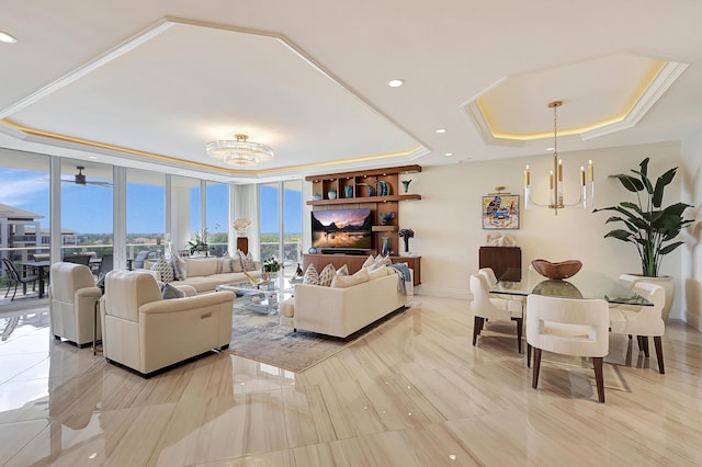 living room with a raised ceiling, a wall of windows, and a chandelier