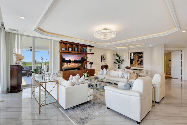 living room with a tray ceiling, a wall of windows, and crown molding