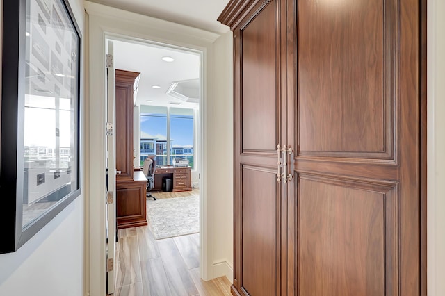 hall with light hardwood / wood-style flooring and expansive windows