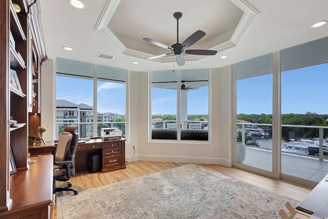 office space with a raised ceiling, crown molding, light hardwood / wood-style flooring, and ceiling fan