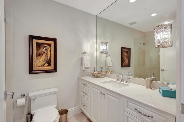 bathroom featuring walk in shower, vanity, and toilet