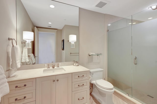 bathroom featuring toilet, vanity, and walk in shower