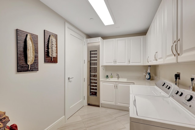 clothes washing area with cabinets, separate washer and dryer, and sink