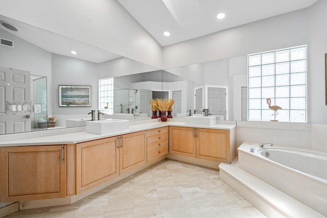 bathroom featuring a skylight, plus walk in shower, high vaulted ceiling, tile patterned floors, and vanity