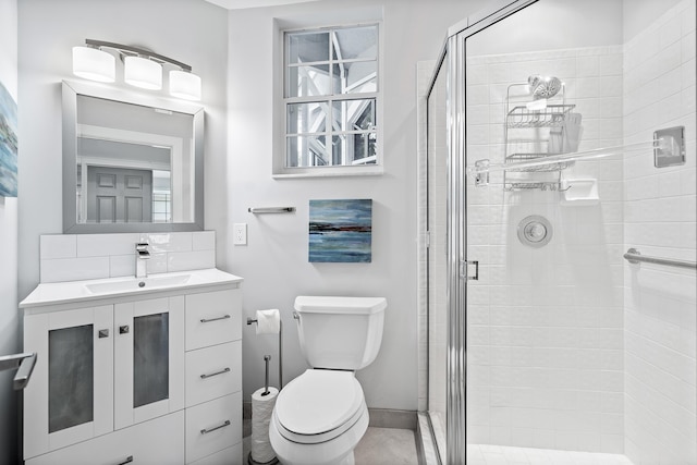 bathroom with vanity, toilet, and a shower with shower door