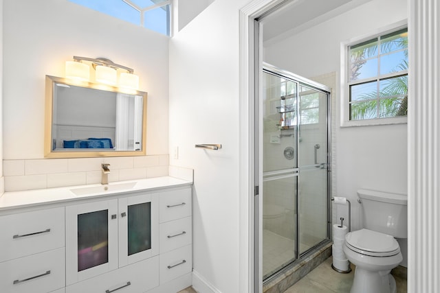 bathroom with tile patterned flooring, vanity, toilet, and an enclosed shower