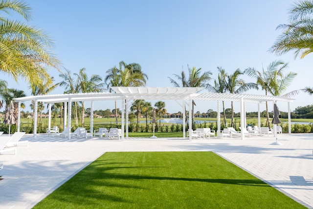 view of home's community featuring a water view, a pergola, a yard, and a patio