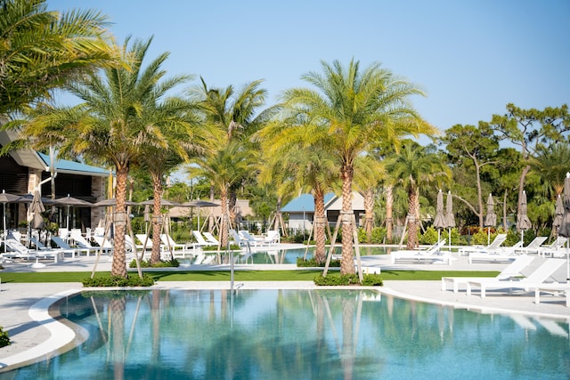 view of swimming pool featuring a water view and a patio