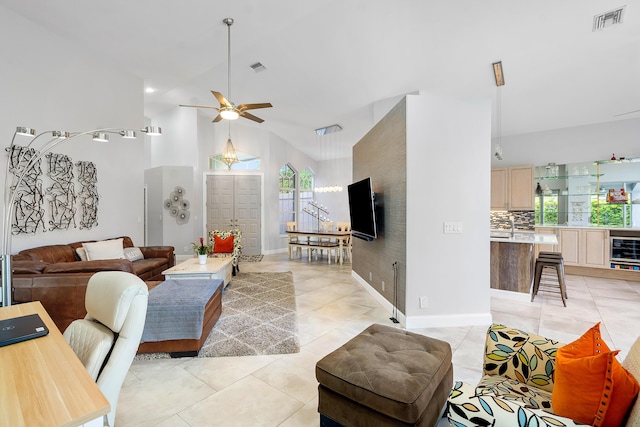 living room featuring ceiling fan, high vaulted ceiling, light tile patterned flooring, and beverage cooler