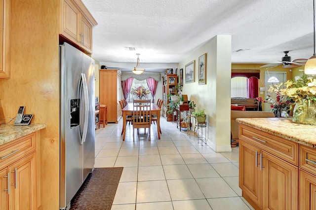 tiled dining room featuring ceiling fan and a textured ceiling