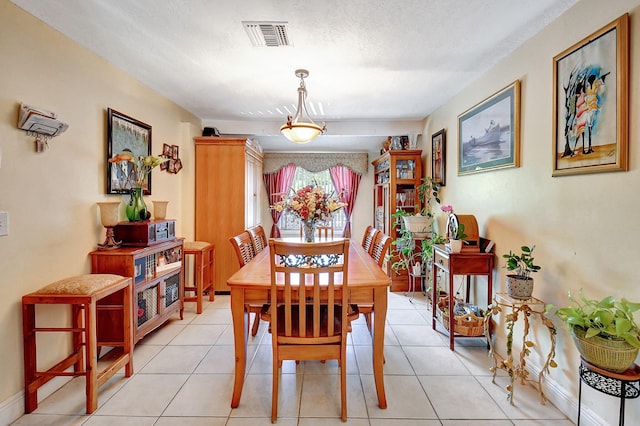 dining area featuring light tile patterned floors and a textured ceiling