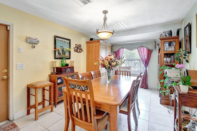 tiled dining area featuring a textured ceiling