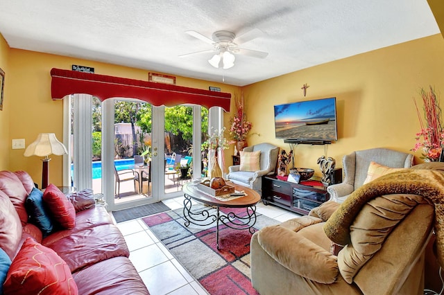 living room featuring ceiling fan, a textured ceiling, and light tile patterned floors