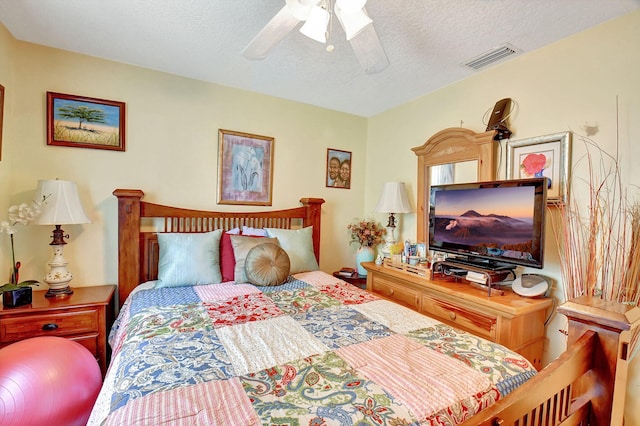 bedroom with a textured ceiling and ceiling fan