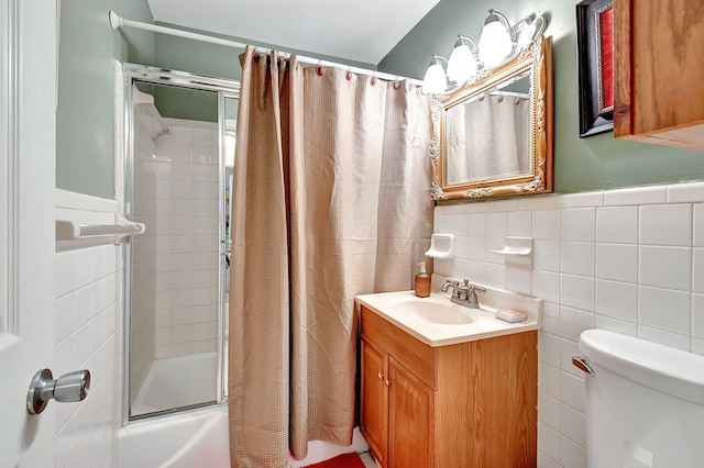 full bathroom with tile walls, vanity, enclosed tub / shower combo, and toilet