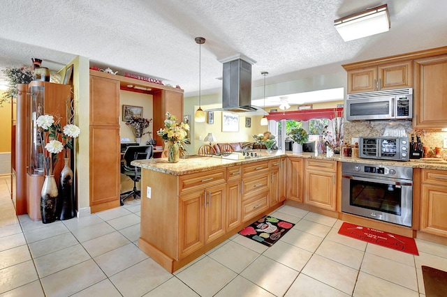 kitchen with appliances with stainless steel finishes, hanging light fixtures, island range hood, a textured ceiling, and kitchen peninsula