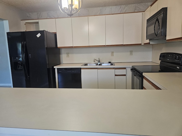 kitchen with white cabinetry, sink, and black appliances