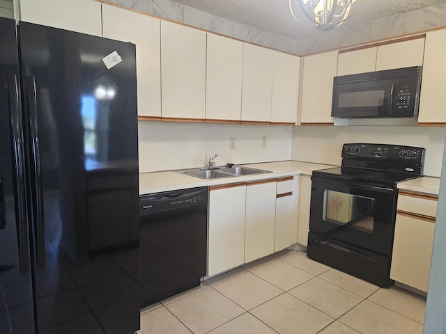 kitchen with white cabinets, a textured ceiling, sink, and black appliances