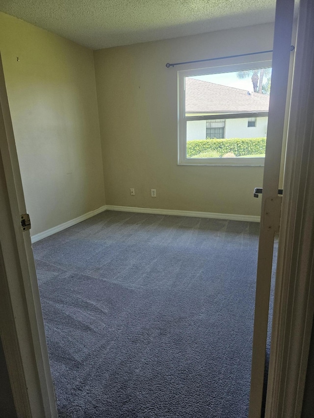 carpeted spare room featuring a textured ceiling