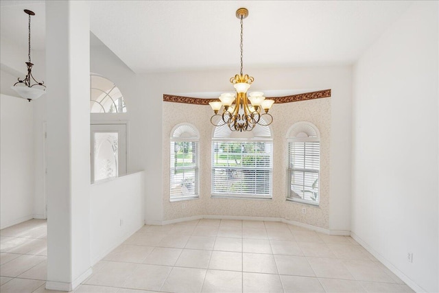 spare room featuring light tile patterned floors and an inviting chandelier