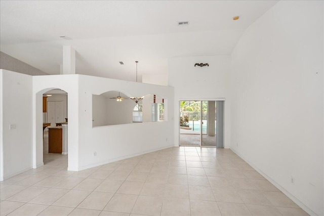 empty room featuring light tile patterned floors, high vaulted ceiling, and ceiling fan