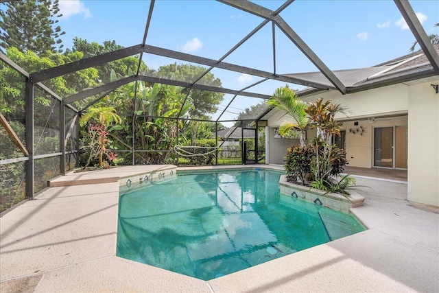 view of swimming pool with a lanai, ceiling fan, and a patio area