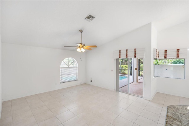 tiled empty room with ceiling fan and vaulted ceiling