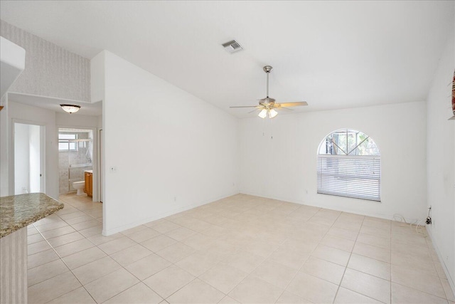 tiled empty room with a wealth of natural light and ceiling fan