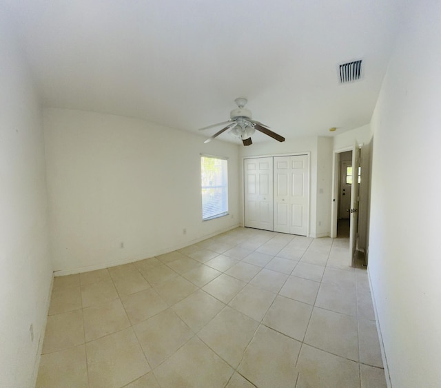 tiled empty room featuring ceiling fan