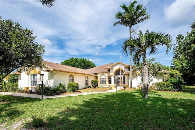 mediterranean / spanish-style home with a front lawn