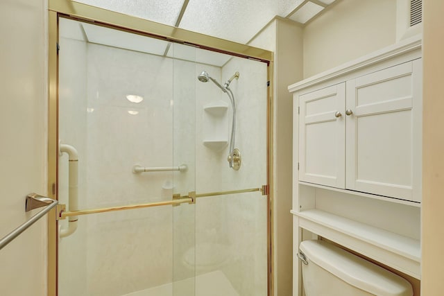 bathroom with a shower with door and toilet